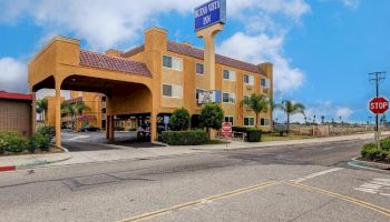 The image shows a hotel with a sign that reads 