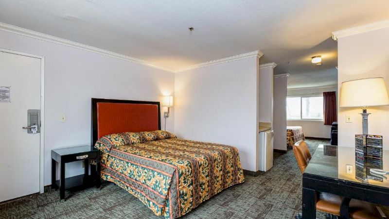A hotel room with a bed, desk, and chair